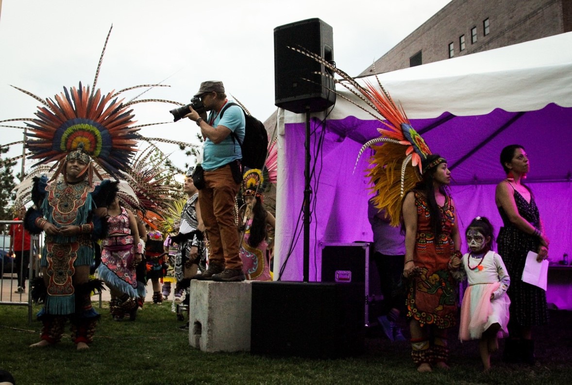 Performers from a local tribal dance group wait offstage to lead the Annual Convention Opening Reception into the North Spark festival center. 