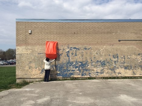 Allentza Michel measures the wall to assess a community mural in progress, as part of violence prevention and community building awareness project at a school in South Side Chicago. 