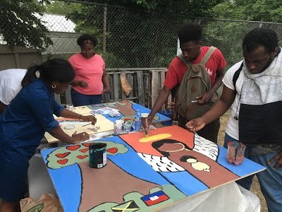 Allentza Michel leads a mural project with teens of the Vigorous Youth program for a community garden. 